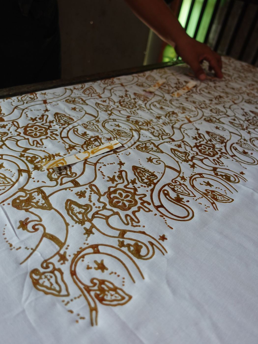 Detail garis canting tembaga yang halus dan presisi pada kain katun mori