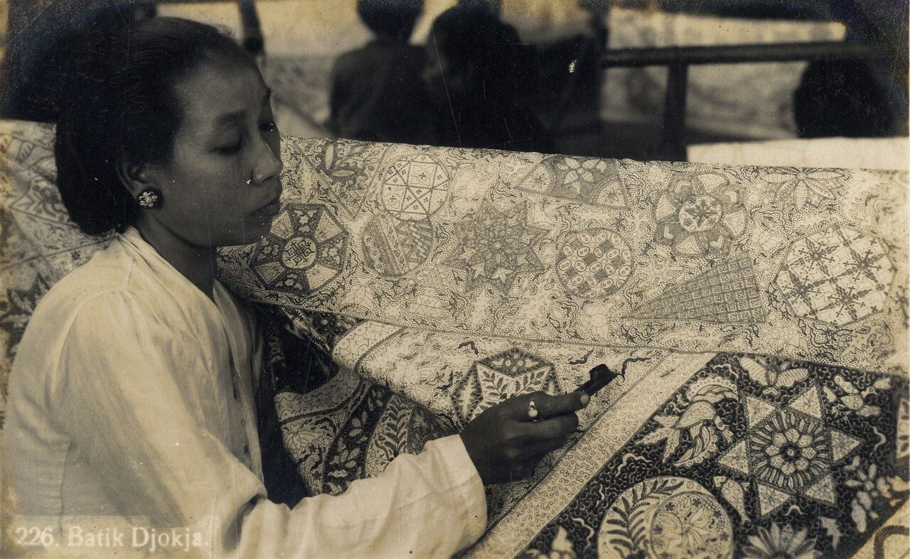 Perajin wanita duduk menggambar batik tulis dengan canting di Yogyakarta, foto sekitar 1930